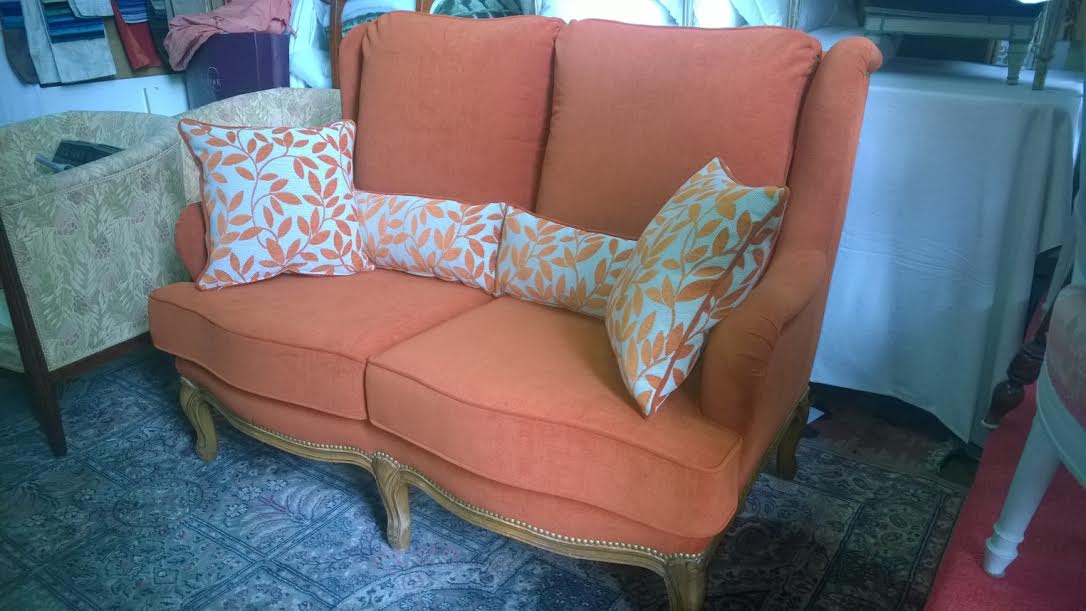 Canapé orange avec ses coussins décoratifs